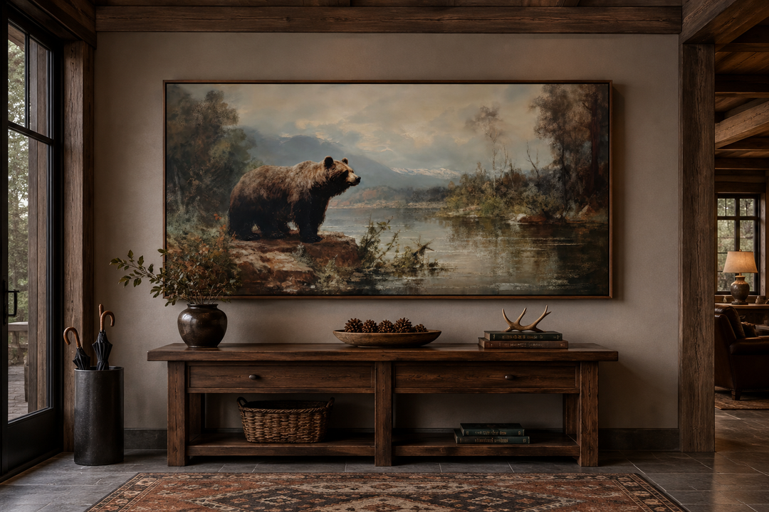 Framed grizzly bear canvas print above a rustic wooden console table in a cabin-style entryway.