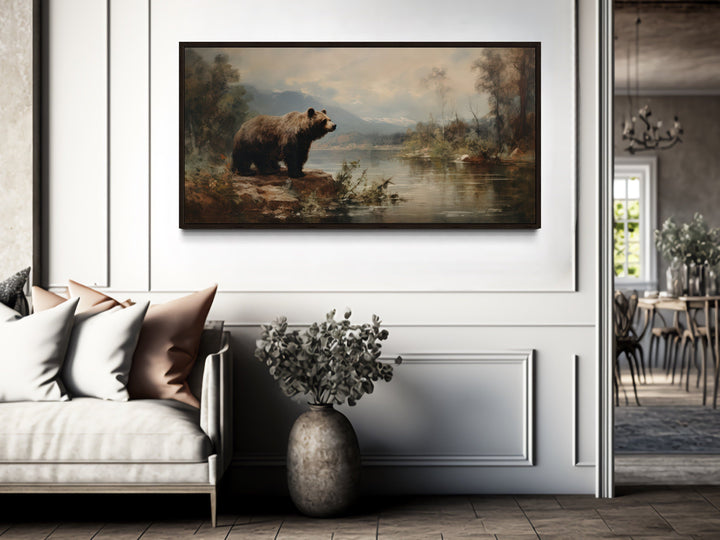 Framed grizzly bear canvas print hanging above a white sofa in a rustic, modern living room.