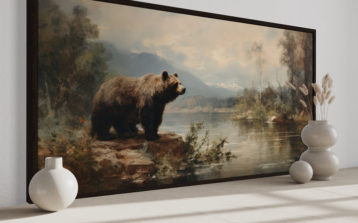 Framed grizzly bear canvas print on a riverbank, rustic cabin wildlife wall art for home decor.
