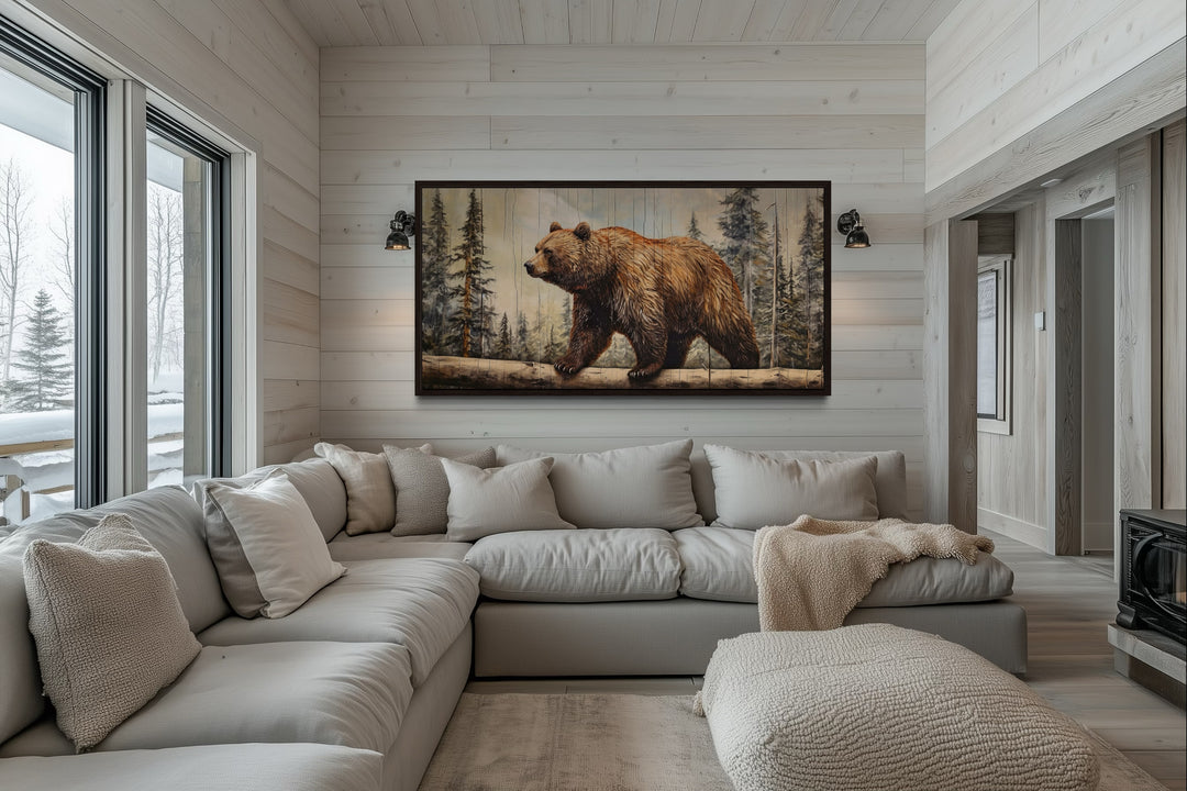 Rustic grizzly bear canvas print with wood effect framed above a sofa in a cabin-style living room.