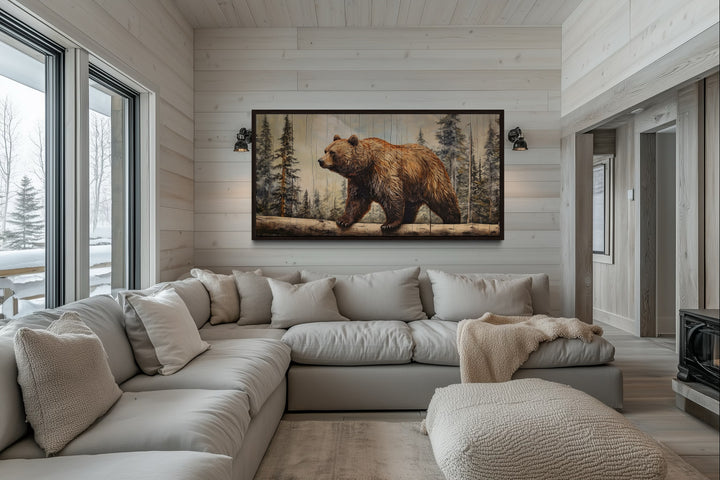Rustic grizzly bear canvas print with wood effect framed above a sofa in a cabin-style living room.
