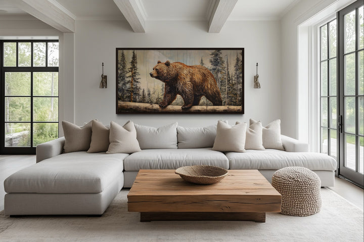 Rustic grizzly bear canvas wall art with wood effect framed above a sofa in a cabin-style room.
