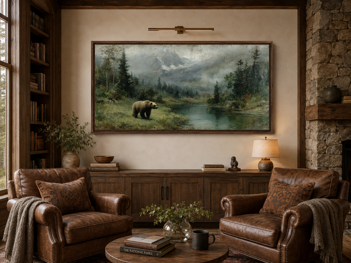 Grizzly bear walking by a mountain lake in a rustic framed canvas wall art above a wooden sideboard.