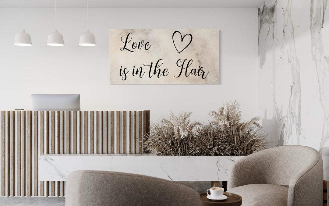 Chic canvas wall art with 'Love is in the Hair' typography in a modern salon reception area.