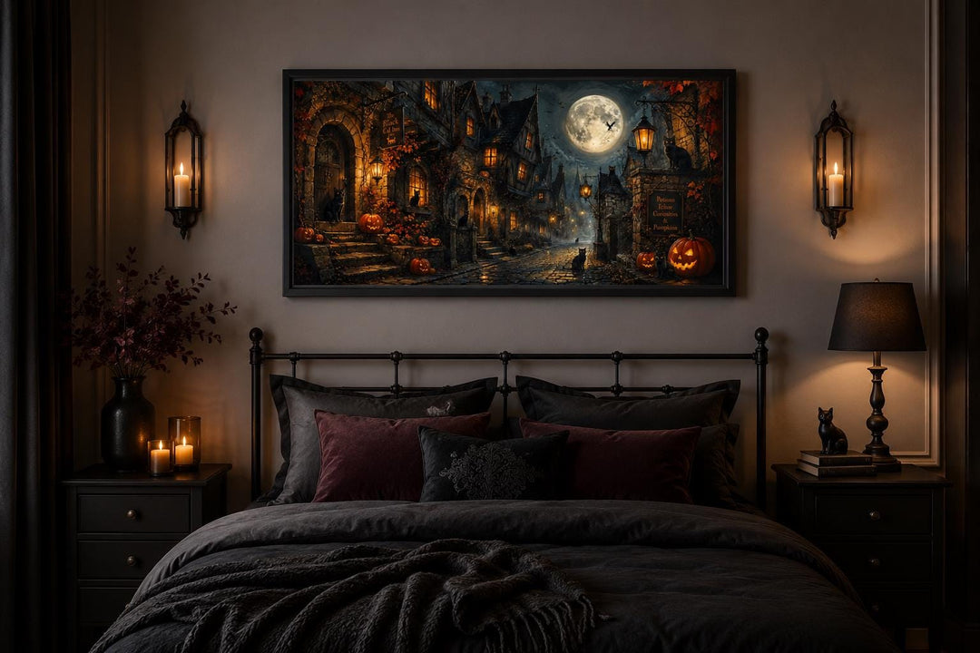 Gothic Halloween village canvas art with a full moon and black cat hanging above a dark metal bed.