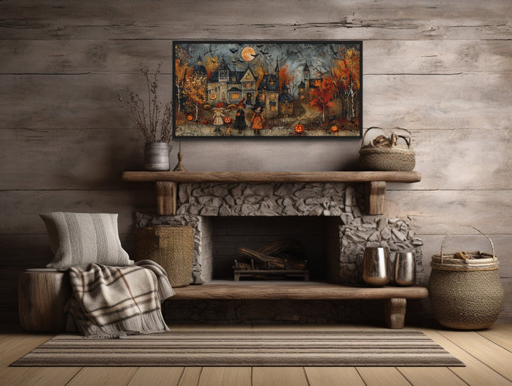 Halloween canvas art of trick-or-treating children in a village, hung above a stone fireplace.