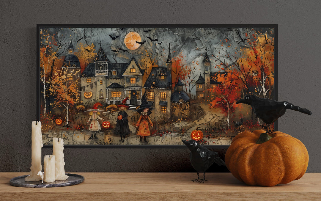 Framed Halloween canvas art of children trick-or-treating in a whimsical village with pumpkins.