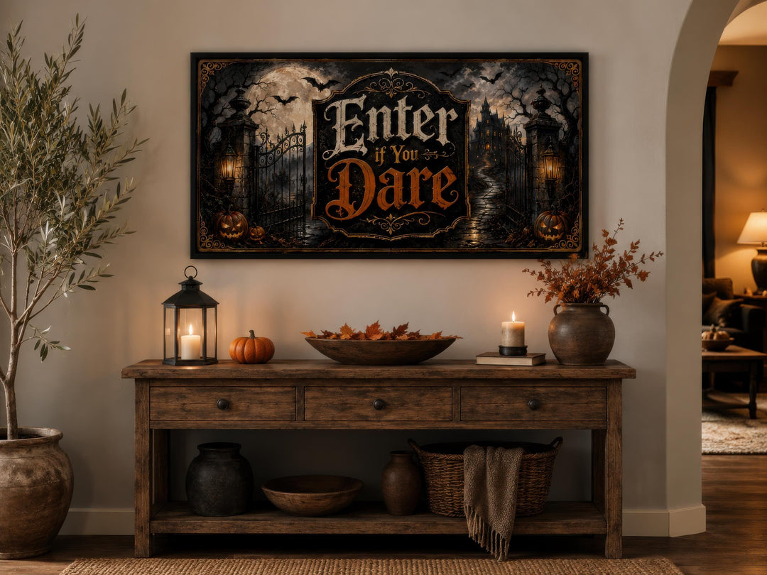 Enter If You Dare Halloween canvas print above a wooden console table with pumpkins and candles.