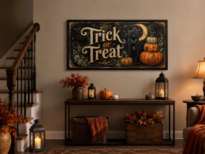 Vintage Trick or Treat canvas wall art with a black cat and pumpkins above a decorated console table