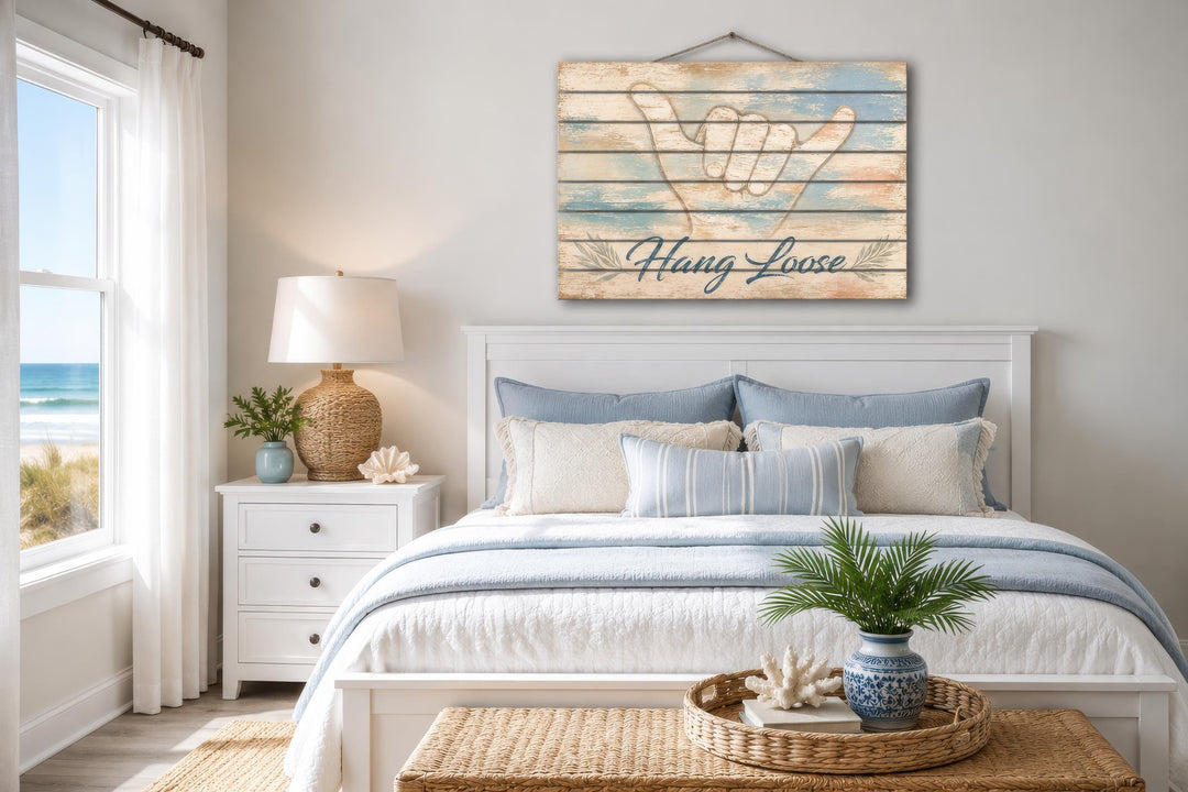 Hang Loose Shaka Sign distressed wood wall art hanging above a bed in a coastal-themed bedroom.