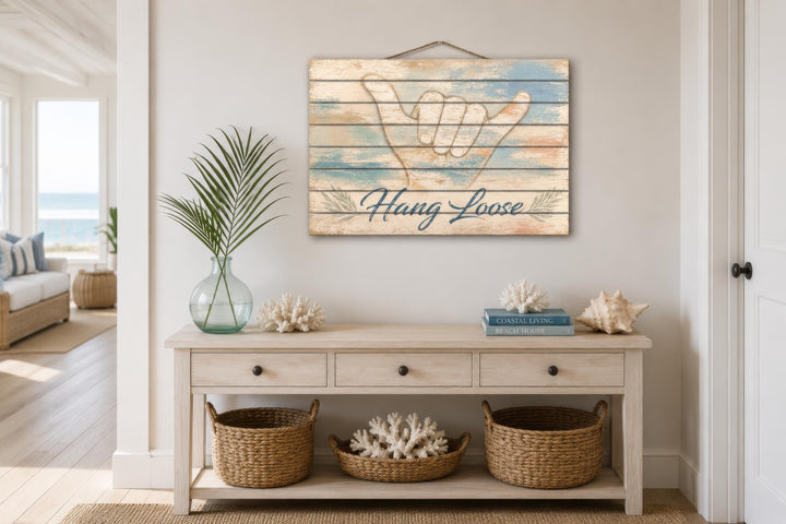 Hang Loose Shaka Sign distressed wood wall art displayed above a coastal-style console table.