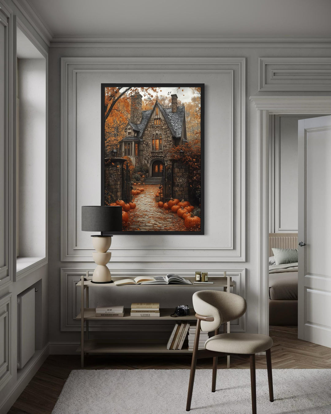 Haunted House and Pumpkin Path Halloween canvas art in a black frame on a white paneled wall.