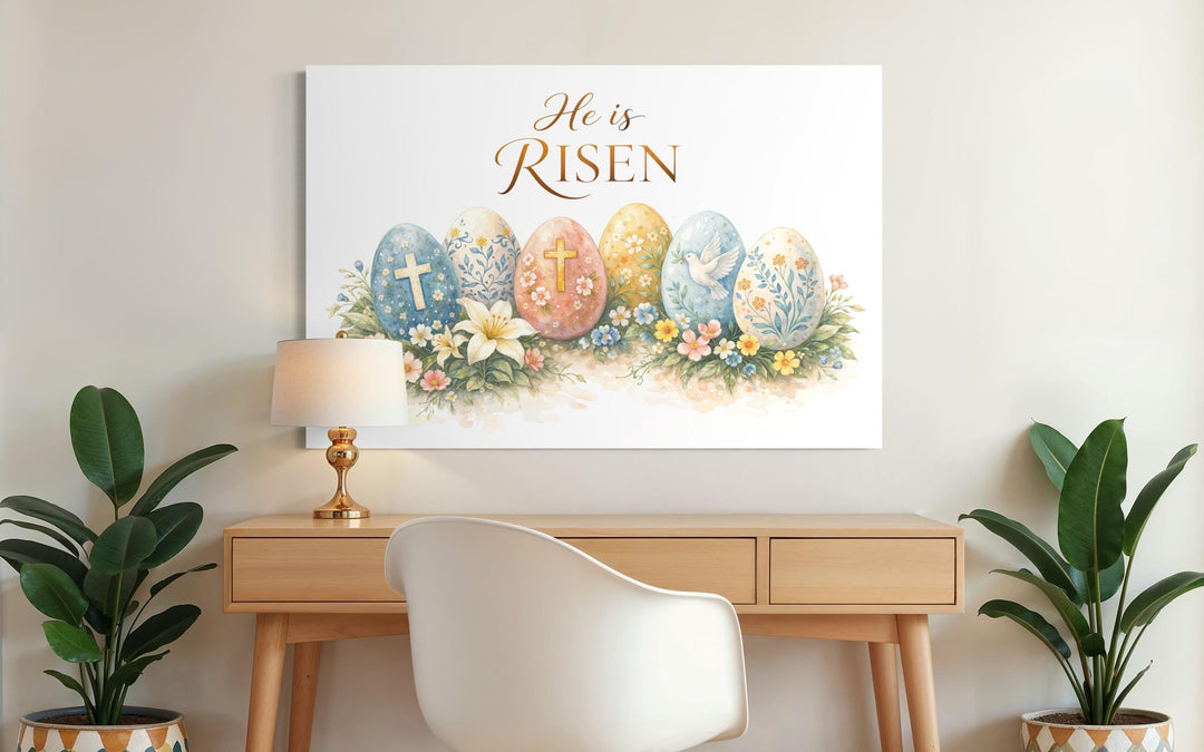 He Is Risen wall art featuring a cross and floral Easter design on canvas above a wooden desk.