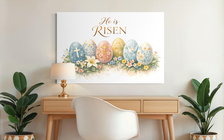 He Is Risen wall art featuring a cross and floral Easter design on canvas above a wooden desk.
