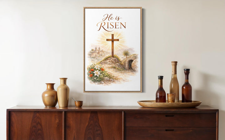 A framed watercolor print of a cross and empty tomb sits above a wooden sideboard with vases.