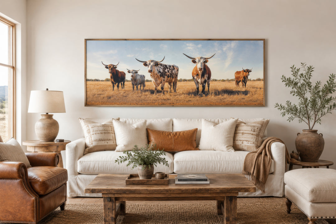Panoramic framed canvas wall art featuring a herd of Texas Longhorn cows in a rustic field.