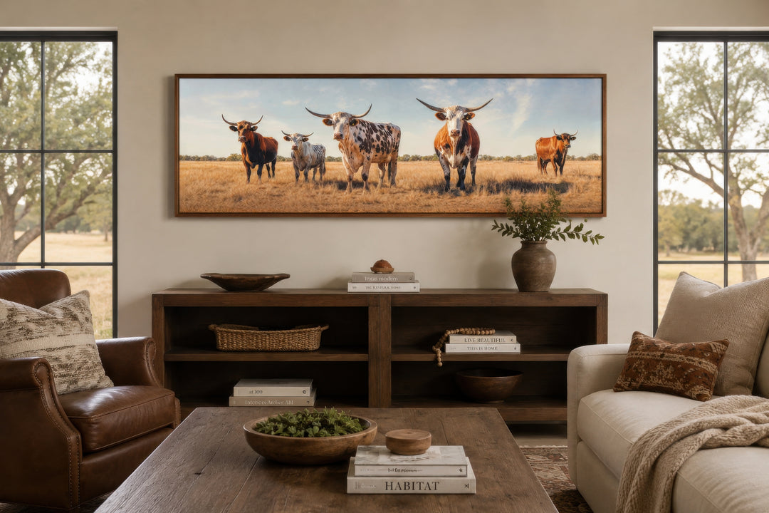 Panoramic framed canvas wall art of a herd of Texas Longhorn cows in a rustic living room setting.