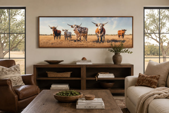 Panoramic framed canvas wall art of a herd of Texas Longhorn cows in a rustic living room setting.