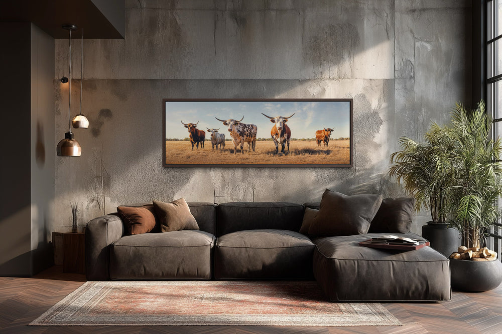 Panoramic framed canvas wall art of a herd of Texas Longhorn cows in a rustic living room.