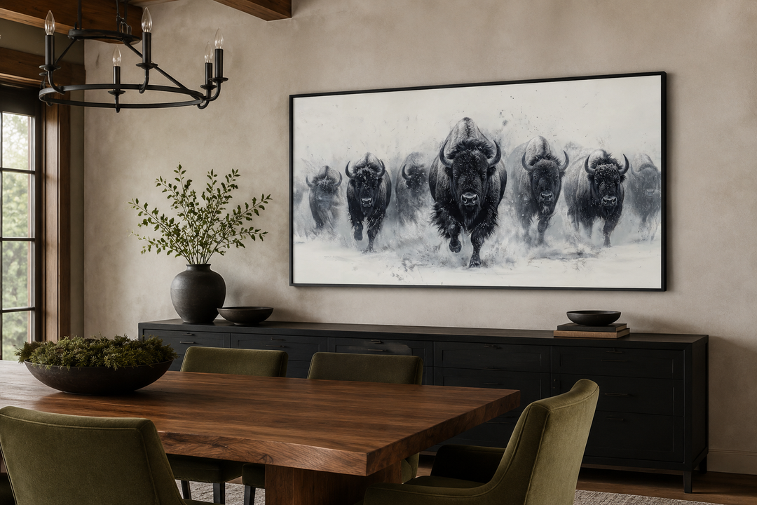 Black and white framed canvas wall art of a bison herd running through snow in a dining room.