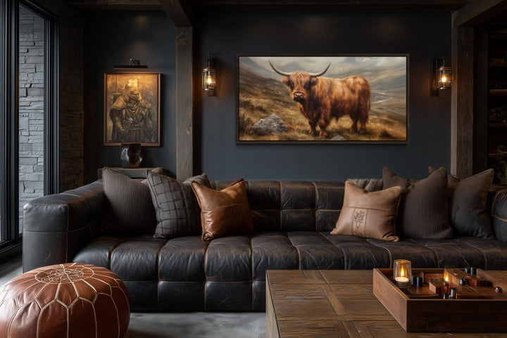 A rustic canvas print of a Highland cow with long horns and thick fur in a dark, moody living room.