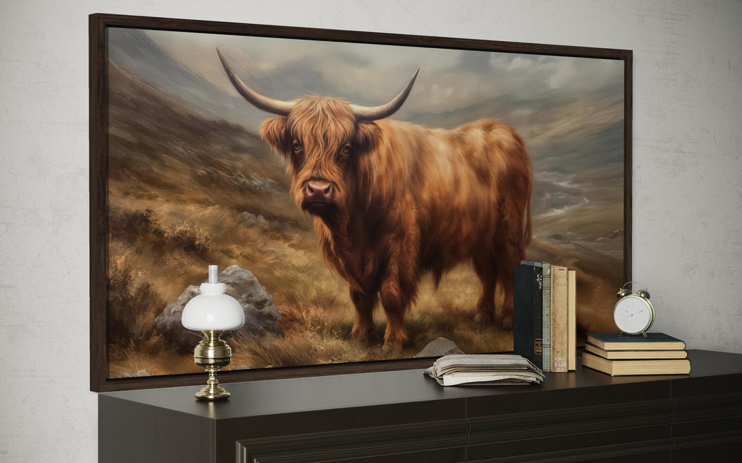 Highland cow rustic farm animal wall art in a dark wood frame above a dresser with vintage books.