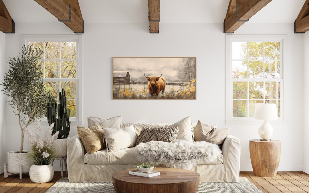 Framed Highland cow canvas wall art above a sofa in a rustic farmhouse living room.