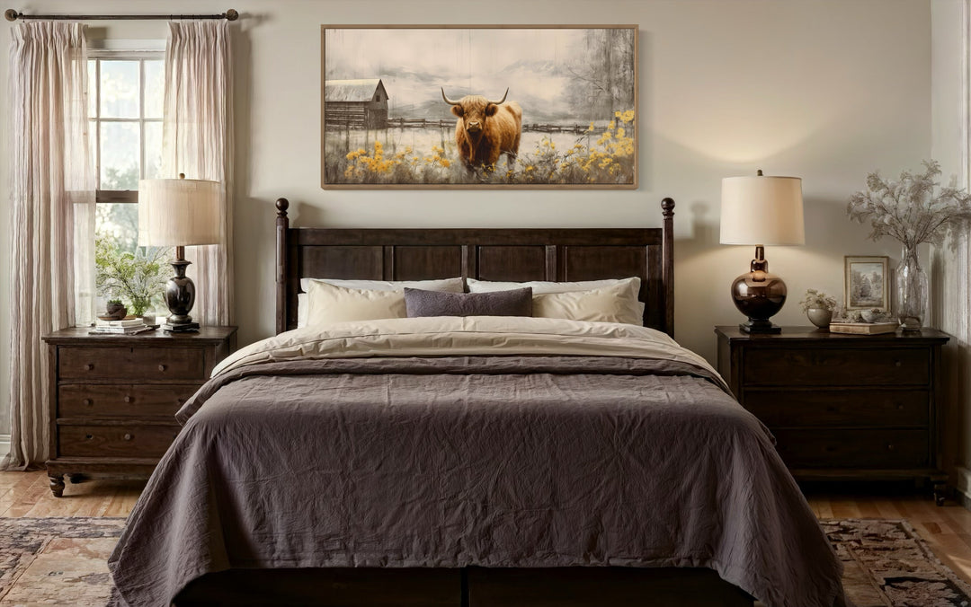 Framed Highland cow canvas wall art hanging above a dark wood bed in a rustic farmhouse bedroom.