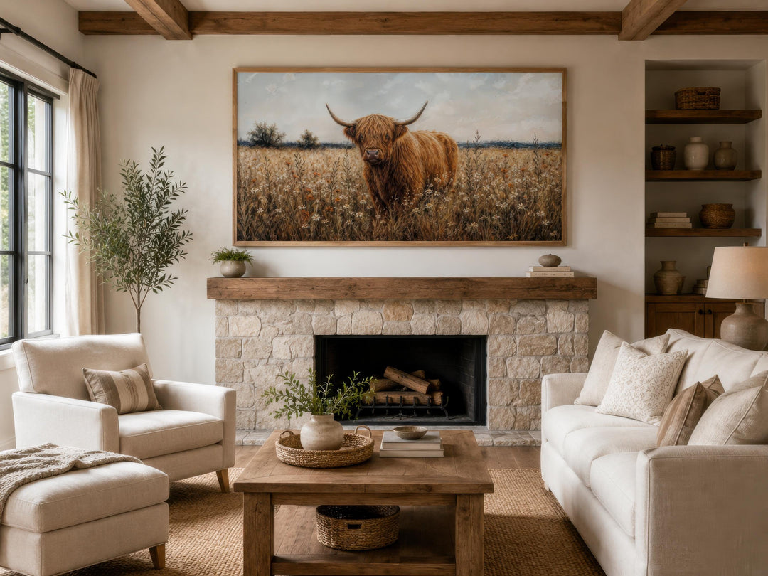 Highland Cow in Wildflower Meadow canvas wall art hanging above a rustic stone fireplace mantel.