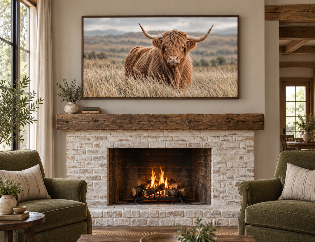 Highland cow photography framed canvas wall art displayed above a rustic brick fireplace.