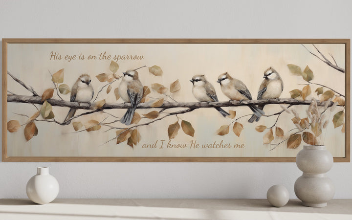Framed canvas wall art of five sparrows on a branch with scripture text in a neutral-toned room.