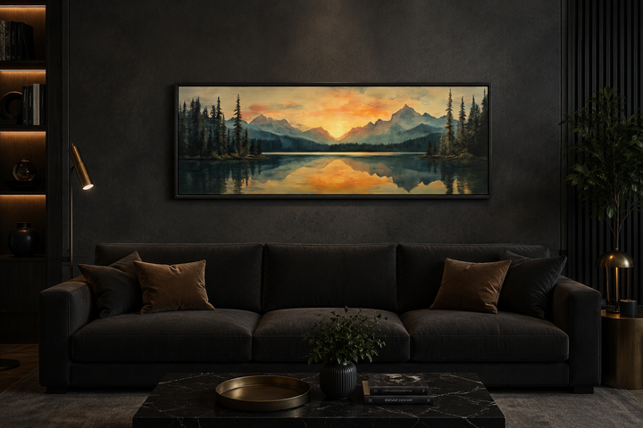 Panoramic mountain lake sunset painting in a black frame above a dark sofa in a modern living room.