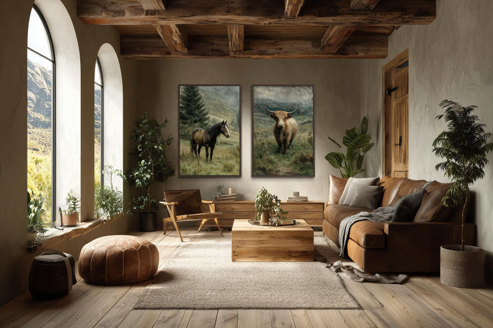 Two vertical canvas prints of a horse and a highland cow in a rustic, earth-toned living room.