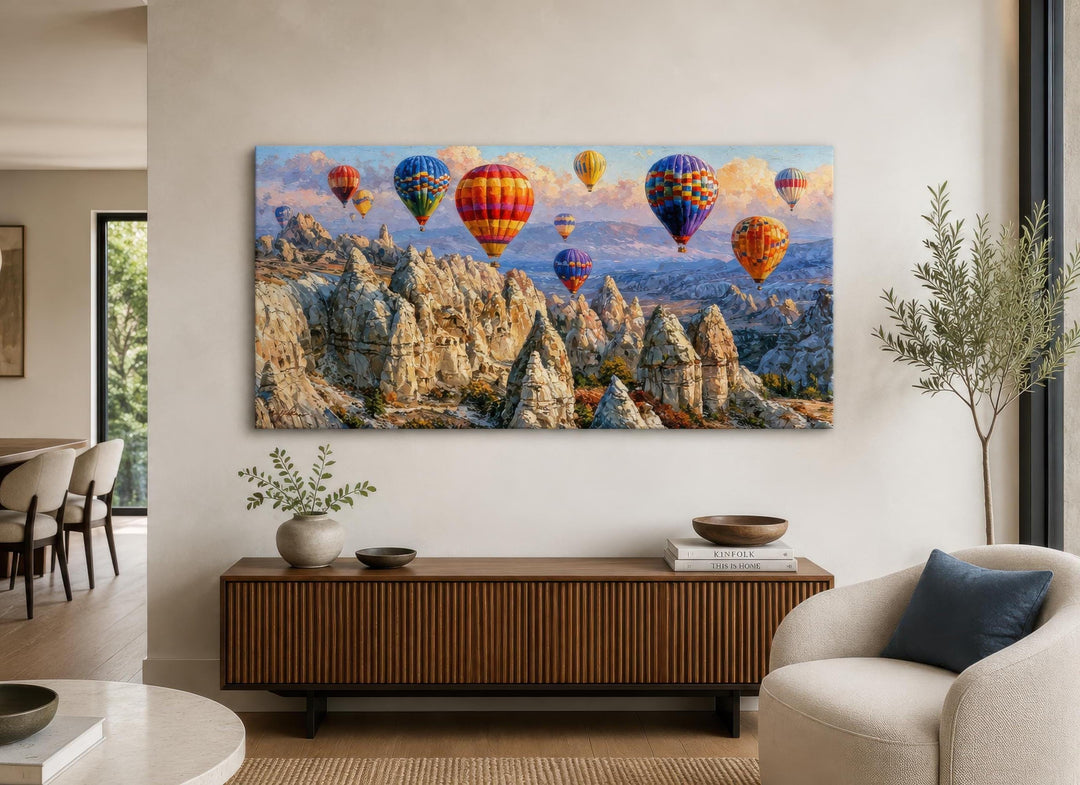 A wide horizontal canvas print of colorful hot air balloons over the Cappadocia landscape.