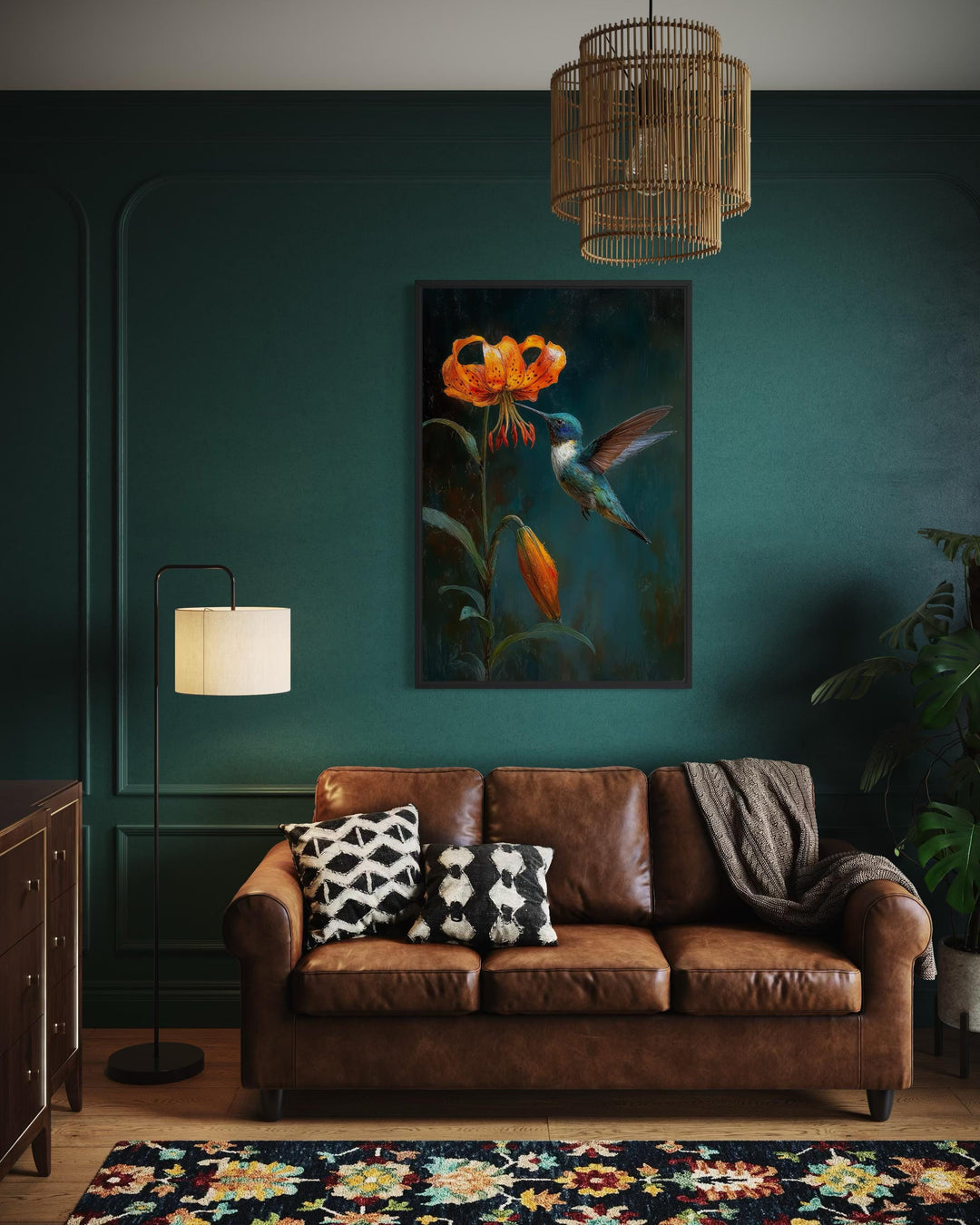 Framed canvas print of a hummingbird and orange lily on a dark green wall in a stylish living room.