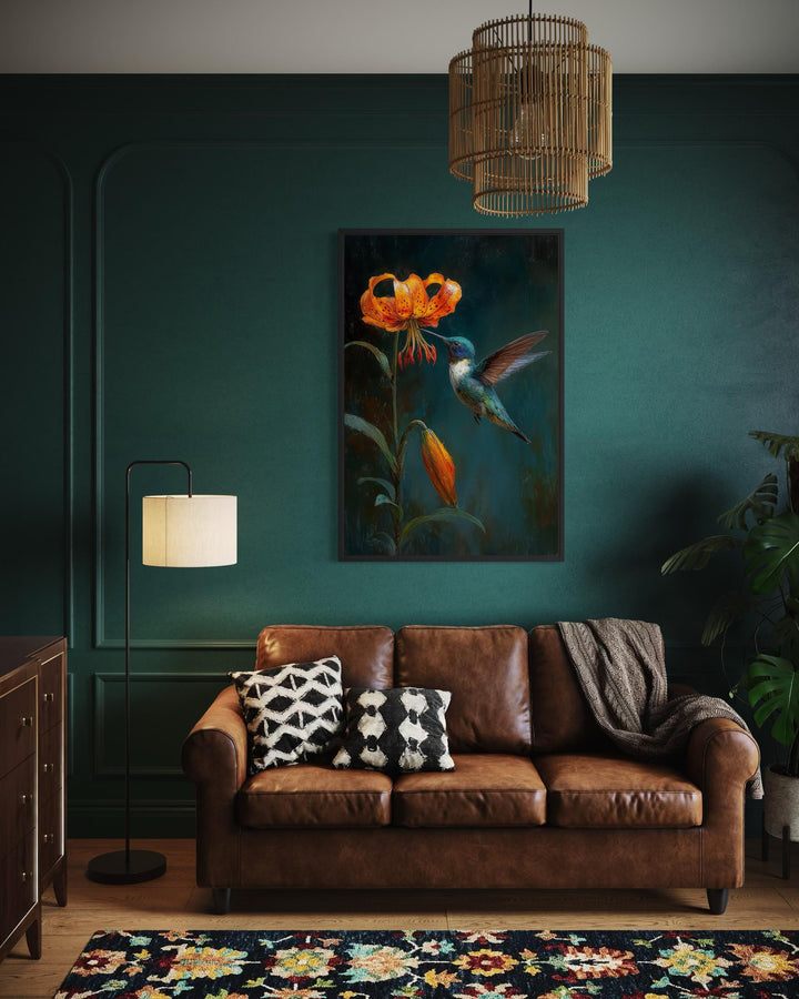 Framed canvas print of a hummingbird and orange lily on a dark green wall in a stylish living room.