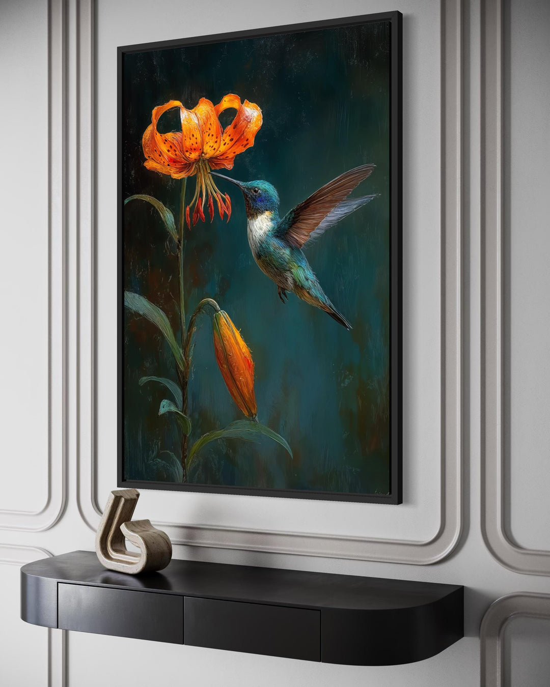 A framed canvas print of a hummingbird hovering near an orange lily against a dark green background.