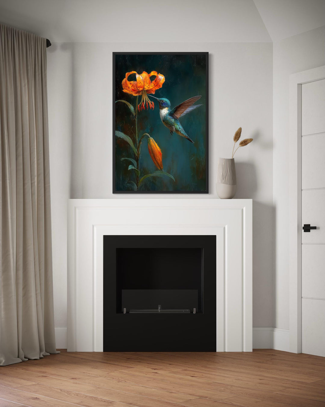 A framed canvas print of a hummingbird and orange lily hangs above a modern white fireplace.