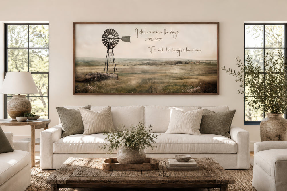 Rustic windmill landscape wall art with quote above a white sofa in a farmhouse living room.