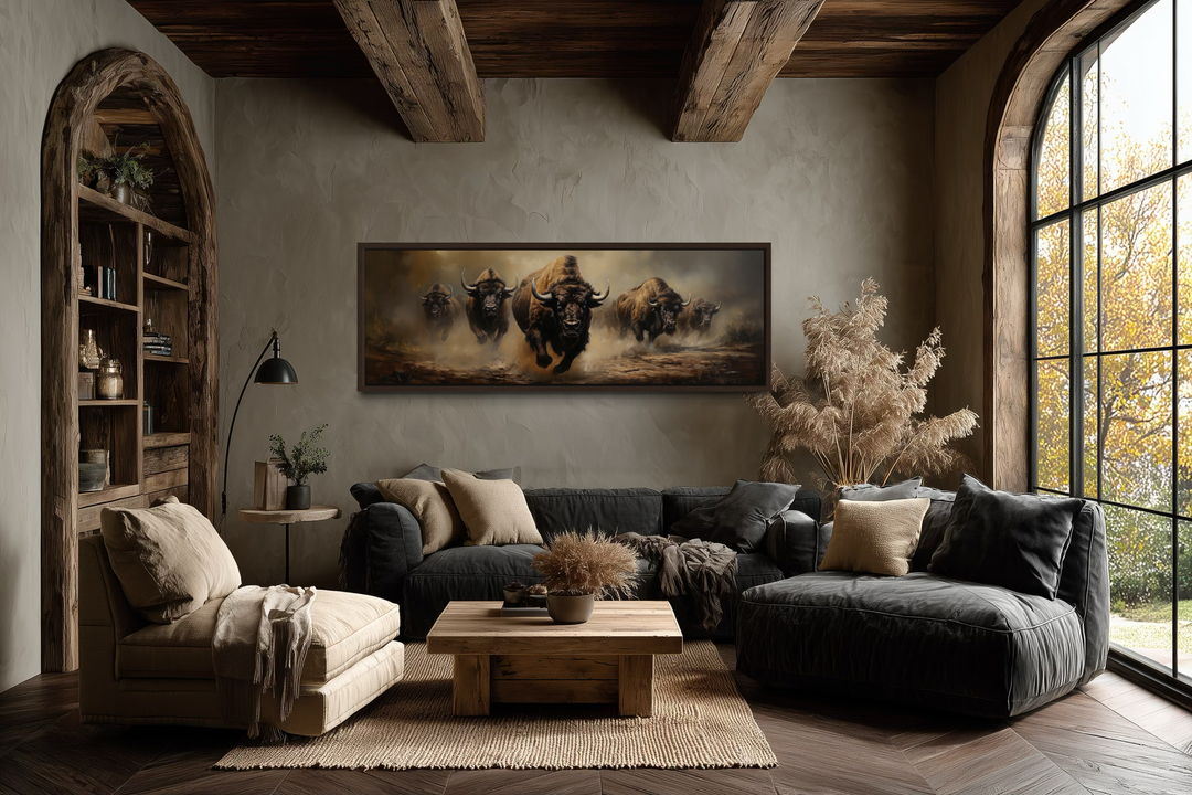 A long horizontal framed canvas featuring a herd of running bison in a rustic living room.