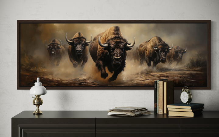 A long horizontal framed canvas featuring a herd of bison charging across a dusty plain.
