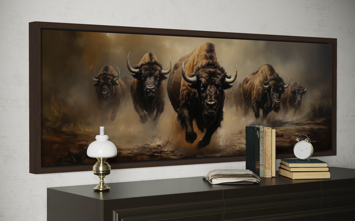 A long horizontal framed canvas featuring a powerful herd of bison charging across a dusty plain.