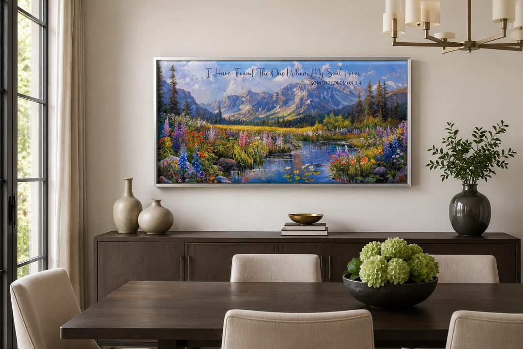Mountain landscape wall art with Scripture text above a dining table in a modern room.