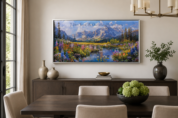 Mountain landscape wall art with Scripture text above a dining table in a modern room.