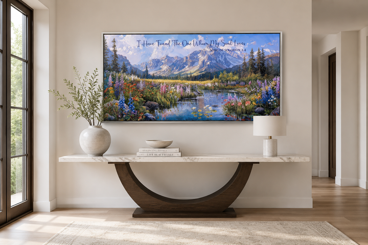 Mountain landscape wall art with Song of Solomon 3:4 scripture above a marble console table.