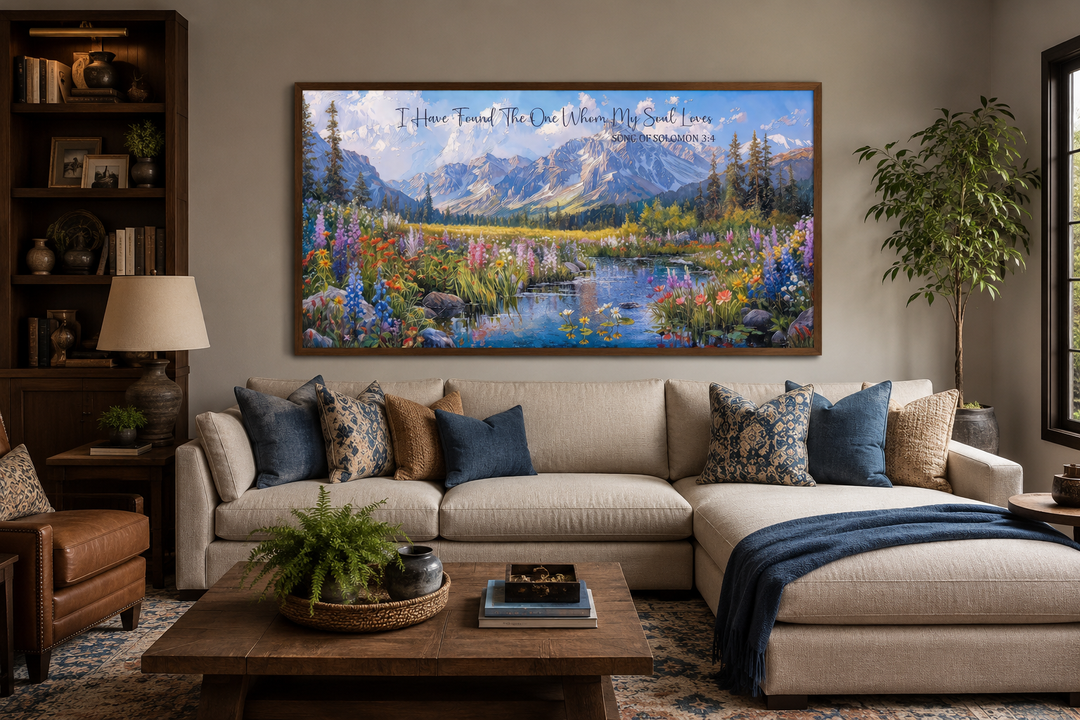 Christian wall art with mountain landscape and scripture above a sofa in a cozy living room.
