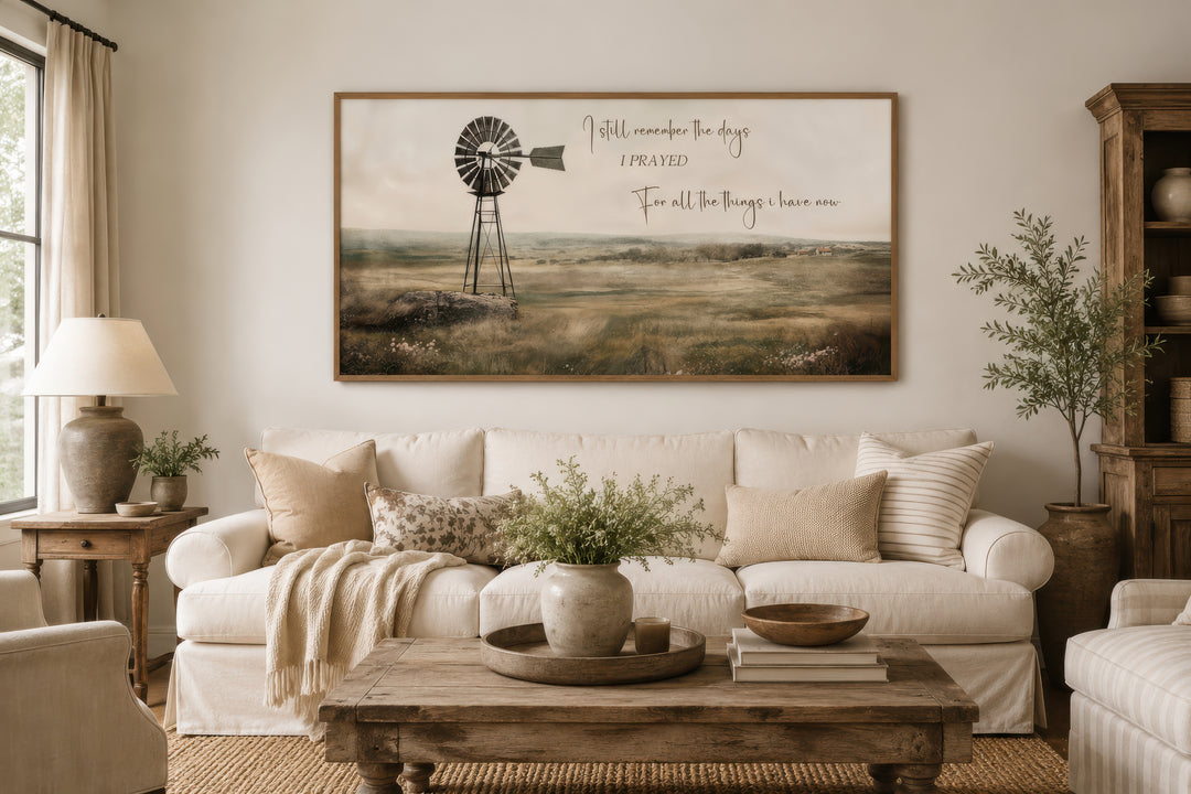 Rustic farm landscape wall art with a windmill and quote above a white sofa in a farmhouse room.
