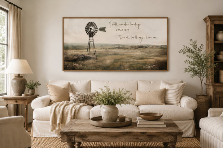 Rustic farm landscape wall art with a windmill and quote above a white sofa in a farmhouse room.