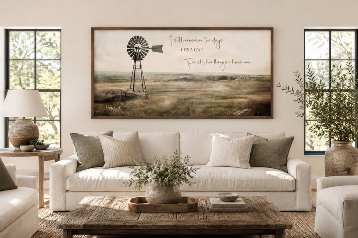 Rustic windmill landscape wall art with quote above a white sofa in a farmhouse living room.