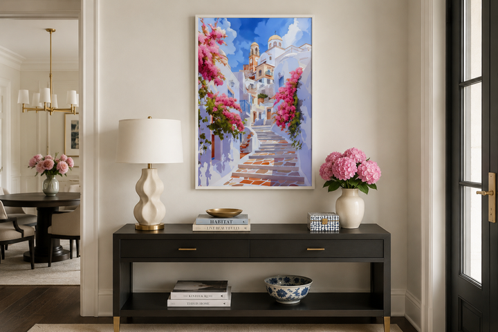 Ibiza Old Town watercolor wall art of a whitewashed street with pink flowers above a black console.